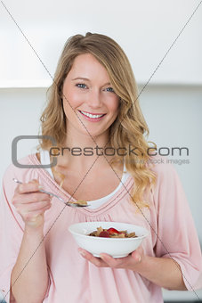 Young woman having cereals in kitchen