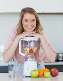 Woman preparing mix fruit juice in liquidizer