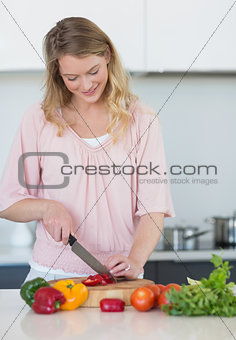 Woman chopping vegetables at kitchen counter