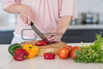 Mid section of woman chopping vegetables