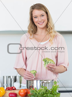 Woman preparing broccoli at kitchen counter