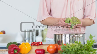 Mid section of woman preparing broccoli