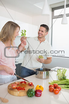 Playful couple preparing food together