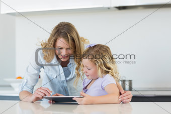 Woman and daughter using tablet computer