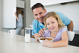 Father and daughter at breakfast table in house