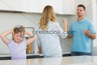 Girl covering ears while parents arguing