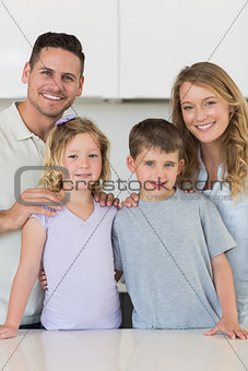Happy family standing together in kitchen