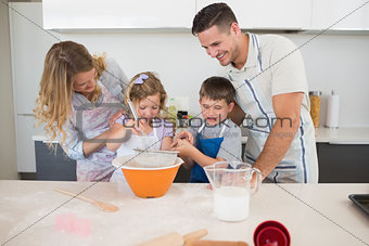 Family preparing cookies at kitchen counter