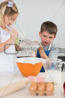 Cute children baking cookies in kitchen
