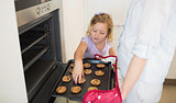Girl with mother baking cookies