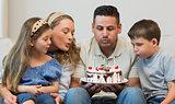 Family blowing candles on cake