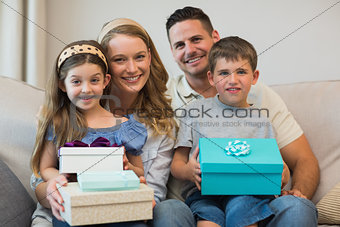 Happy family with gifts on sofa