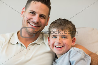 Happy father and son on sofa