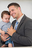 Businessman carrying baby boy at home