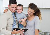 Happy baby with parents using digital tablet