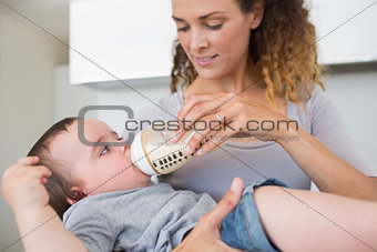 Mother feeding milk to cute baby