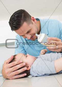 Father feeding milk to baby