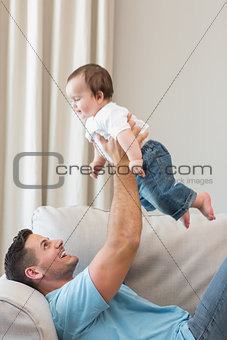 Happy father playing with cute baby