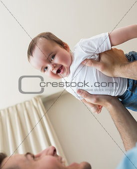 cheerful baby being carried by father