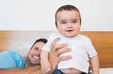 Cute baby with father in bed