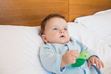 Baby holding toy in bed