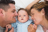 Cute baby with parents in bed