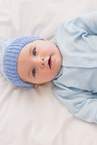 Innocent baby wearing knit hat in bed