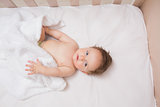 Adorable baby boy lying in crib