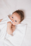 Cute baby holding blanket in crib