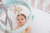 Baby looking at toys hanging in crib