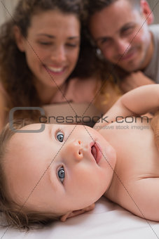 Cute baby with parents in background
