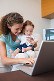 Mother showing laptop to baby