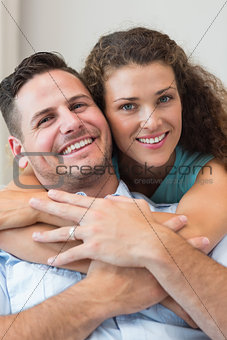 Smiling woman embracing man at home