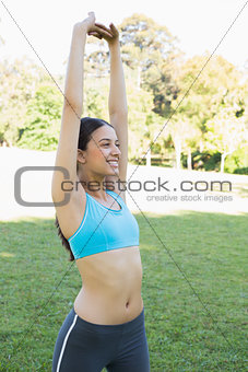 Smiling woman stretching at park