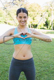 Woman in sportswear showing heart shape