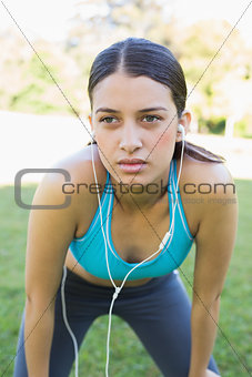 Fit woman listening music in park