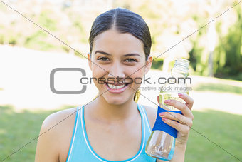 Happy sporty woman holding water bottle