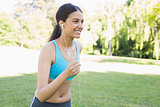 Sporty woman jogging while listening music