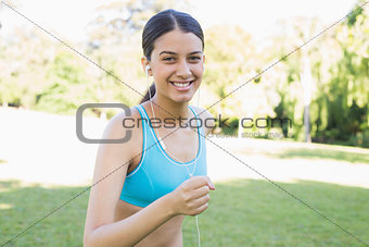 Happy female jogger listening music