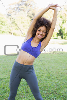 Happy woman stretching in park