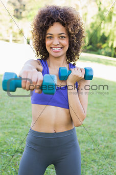 Woman lifting dumbbells in park