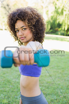 Confident woman lifting dumbbell