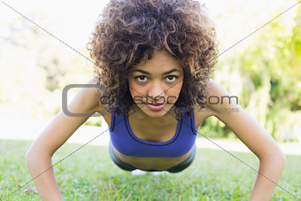Sporty woman doing push ups in park