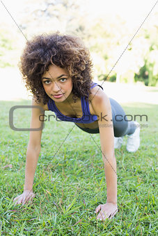 Determined woman doing push ups in park