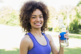 Confident sporty woman holding water bottle