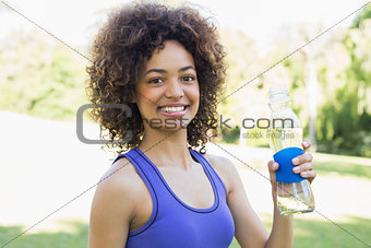 Confident sporty woman holding water bottle