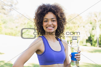 Happy fit woman holding water bottle