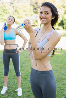 Fit women drinking water in park