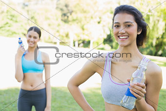 Beautiful sporty women holding water bottles