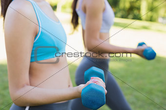 Women lifting free weights in par